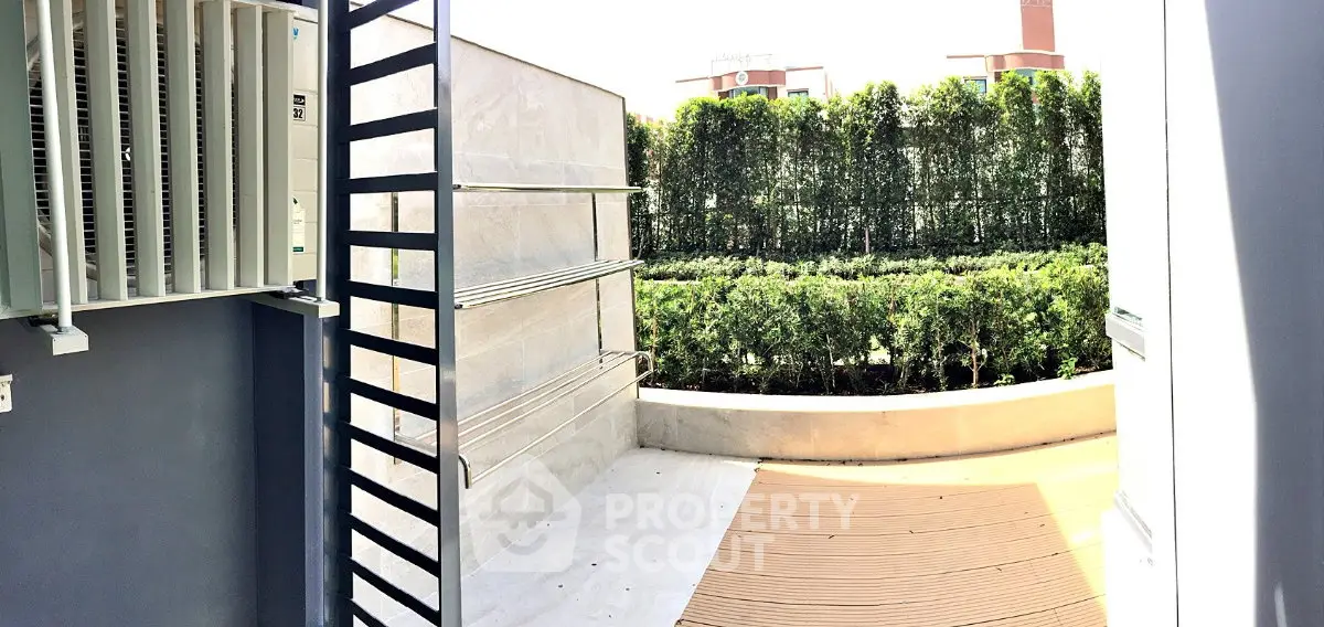 Spacious outdoor balcony with lush greenery and modern design, perfect for relaxation and entertainment.