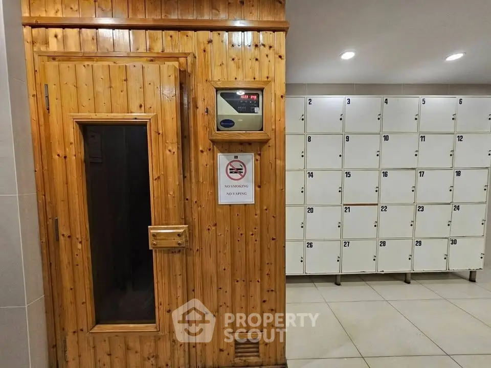 Modern sauna room with wooden door and lockers in a wellness facility.