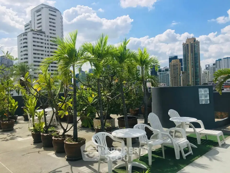 Stunning rooftop garden with city skyline views and cozy seating area.