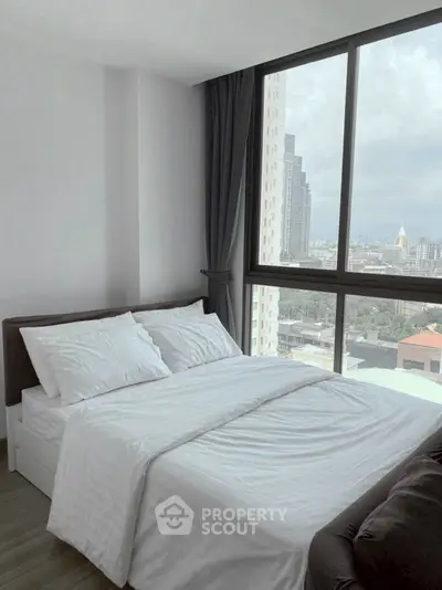 Modern bedroom with large window offering stunning city view