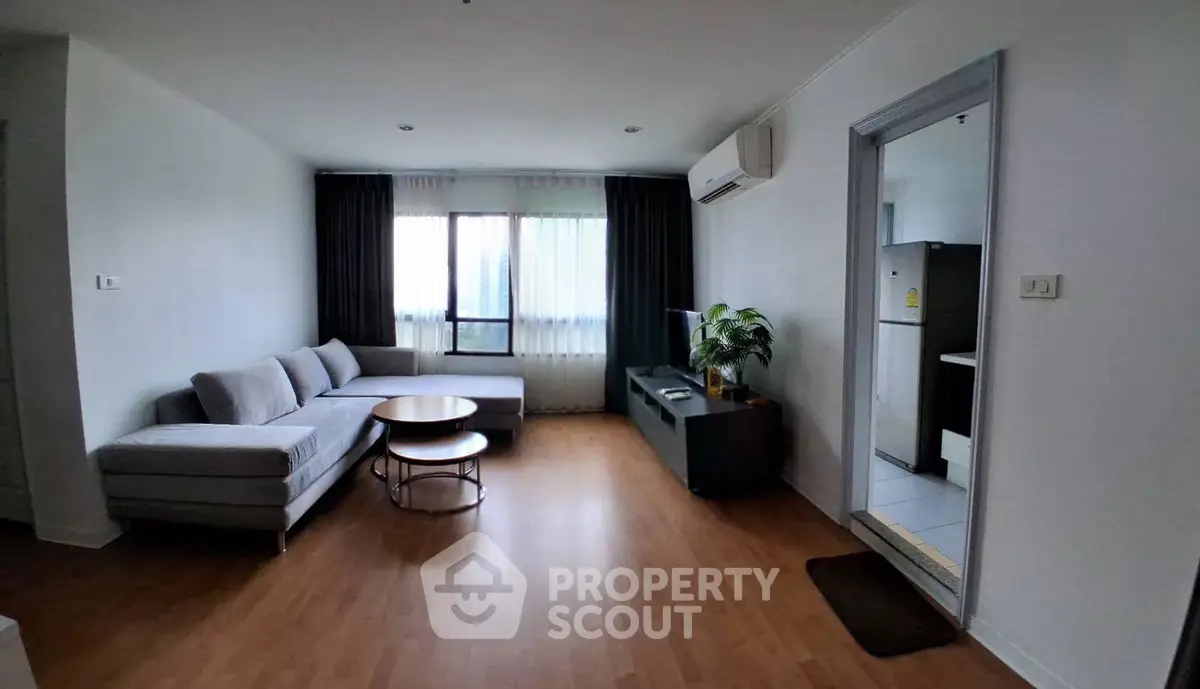 Spacious living room with modern furniture and natural light in a stylish apartment.