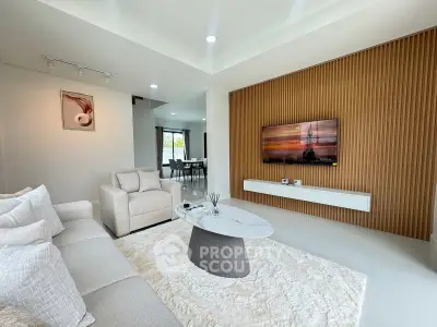 Modern living room with elegant decor and wall-mounted TV, featuring a cozy seating area and stylish coffee table.