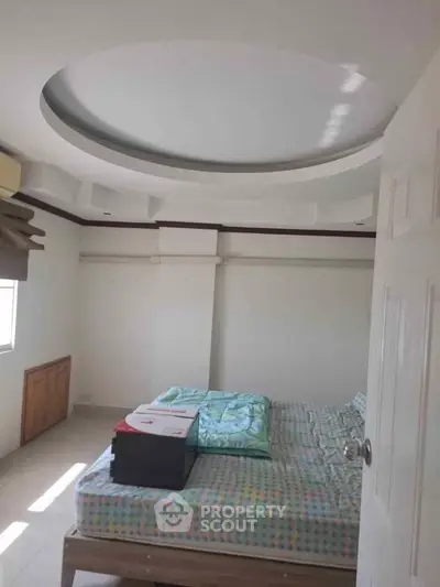 Spacious bedroom with unique ceiling design and natural light