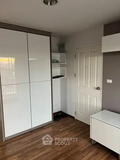 Modern bedroom with sleek white wardrobe and wooden flooring