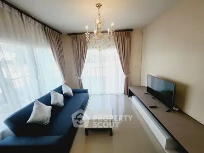 Elegant living room with chandelier, modern sofa, and large windows for natural light.