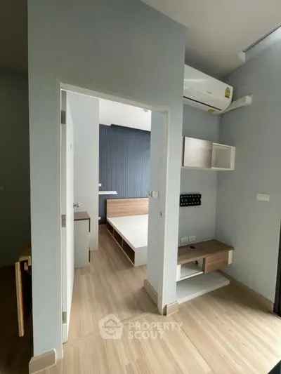 Modern bedroom with wooden flooring and built-in air conditioning unit.