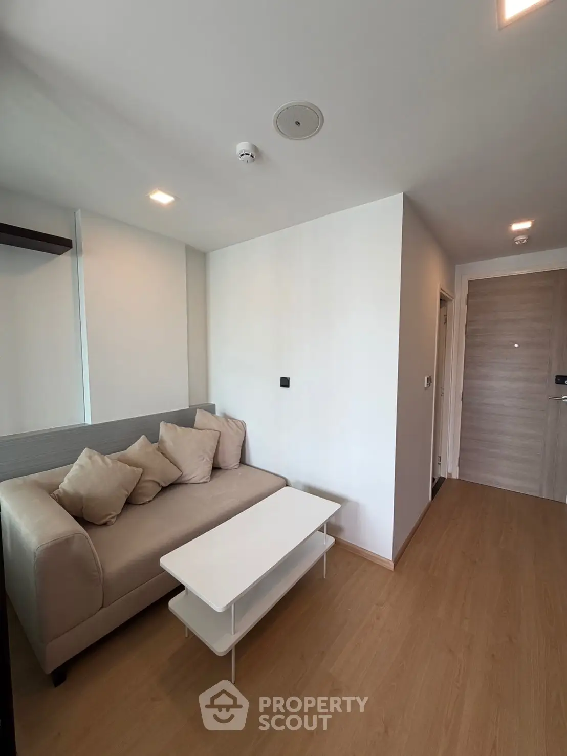 Modern living room with cozy sofa and sleek wooden flooring in a stylish apartment.