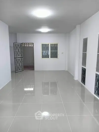 Spacious and bright living room with tiled flooring and modern windows.