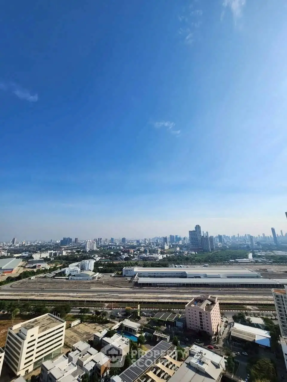 Stunning cityscape view from high-rise building showcasing urban skyline and blue sky.