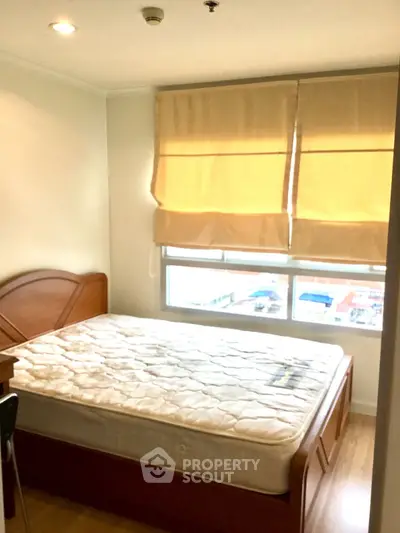 Cozy bedroom with natural light and wooden furniture, perfect for restful nights.