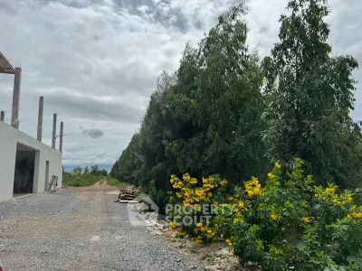 Scenic view of a construction site with lush greenery and vibrant yellow flowers.