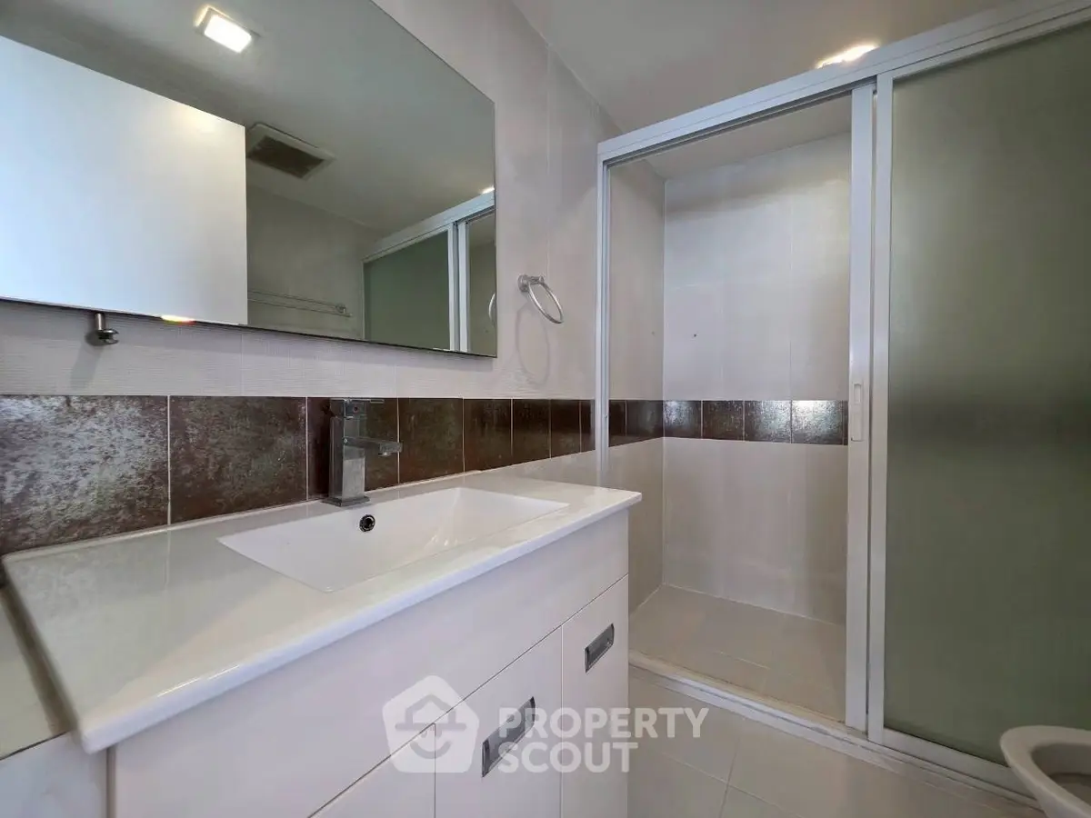 Modern bathroom with sleek fixtures and spacious shower area.