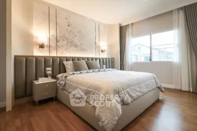 Luxurious bedroom with elegant decor and large window offering natural light
