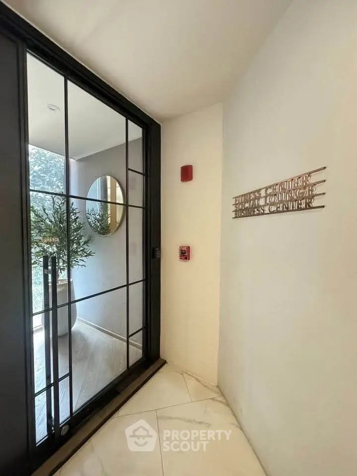 Elegant entrance to a business center with modern glass door and stylish decor.