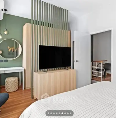 Modern bedroom with stylish decor and TV, featuring a unique partition design.