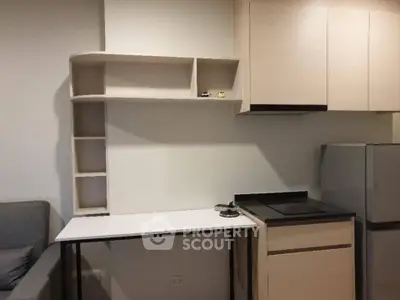 Modern compact kitchen with sleek cabinetry and integrated appliances in a cozy apartment.