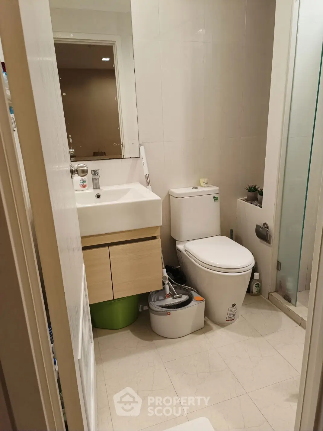 Modern bathroom with sleek fixtures and compact design, featuring a shower and stylish vanity.