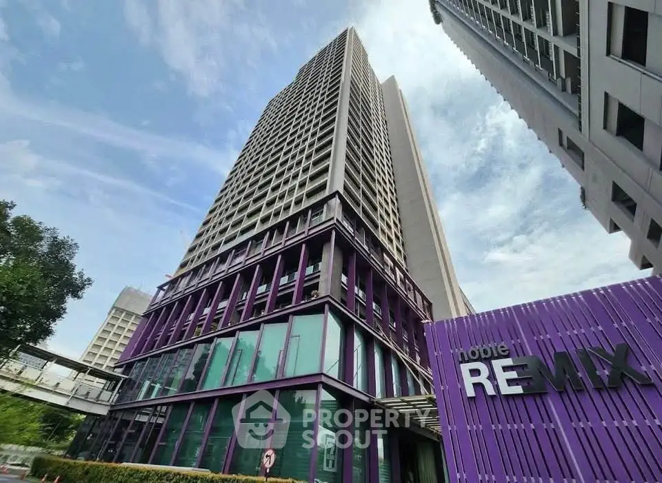 Modern high-rise building with striking purple accents and clear blue sky backdrop.