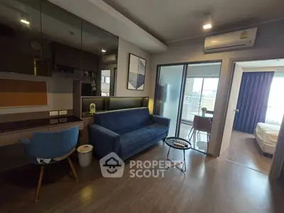Modern living room with blue sofa, glass table, and balcony view in stylish apartment.