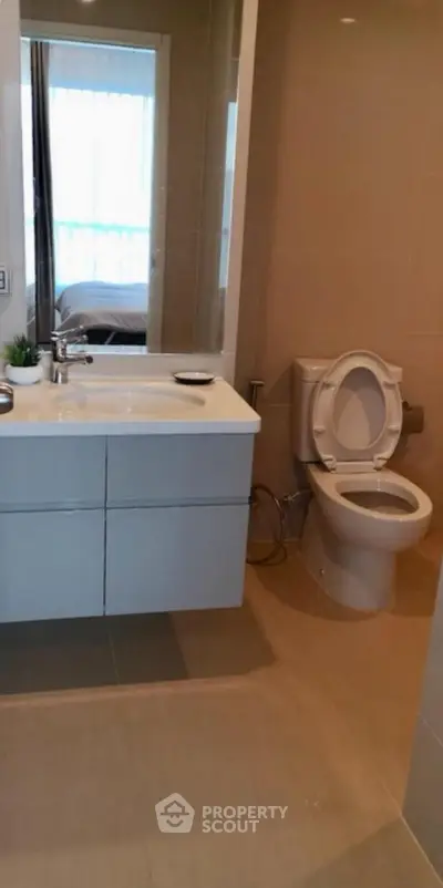 Modern bathroom with sleek fixtures and large mirror in a contemporary apartment.