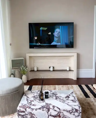 Stylish living room with marble coffee table and mounted TV for modern comfort.