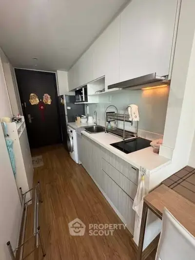 Modern kitchen with sleek cabinetry and integrated appliances in a compact layout.