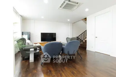 Spacious modern living room with stylish furniture and wooden flooring, perfect for relaxation and entertainment.