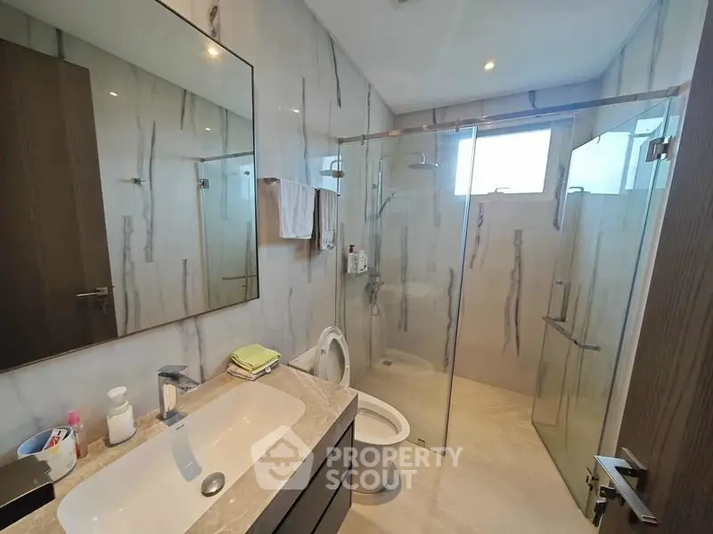 Modern bathroom with glass shower and elegant marble walls