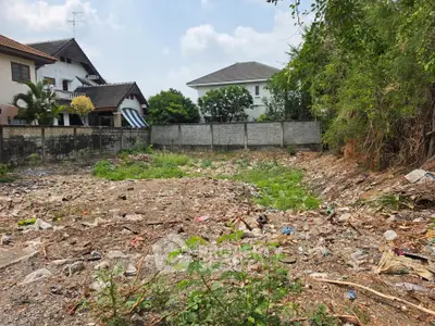 Vacant land plot surrounded by residential houses, ideal for new construction or investment opportunity.