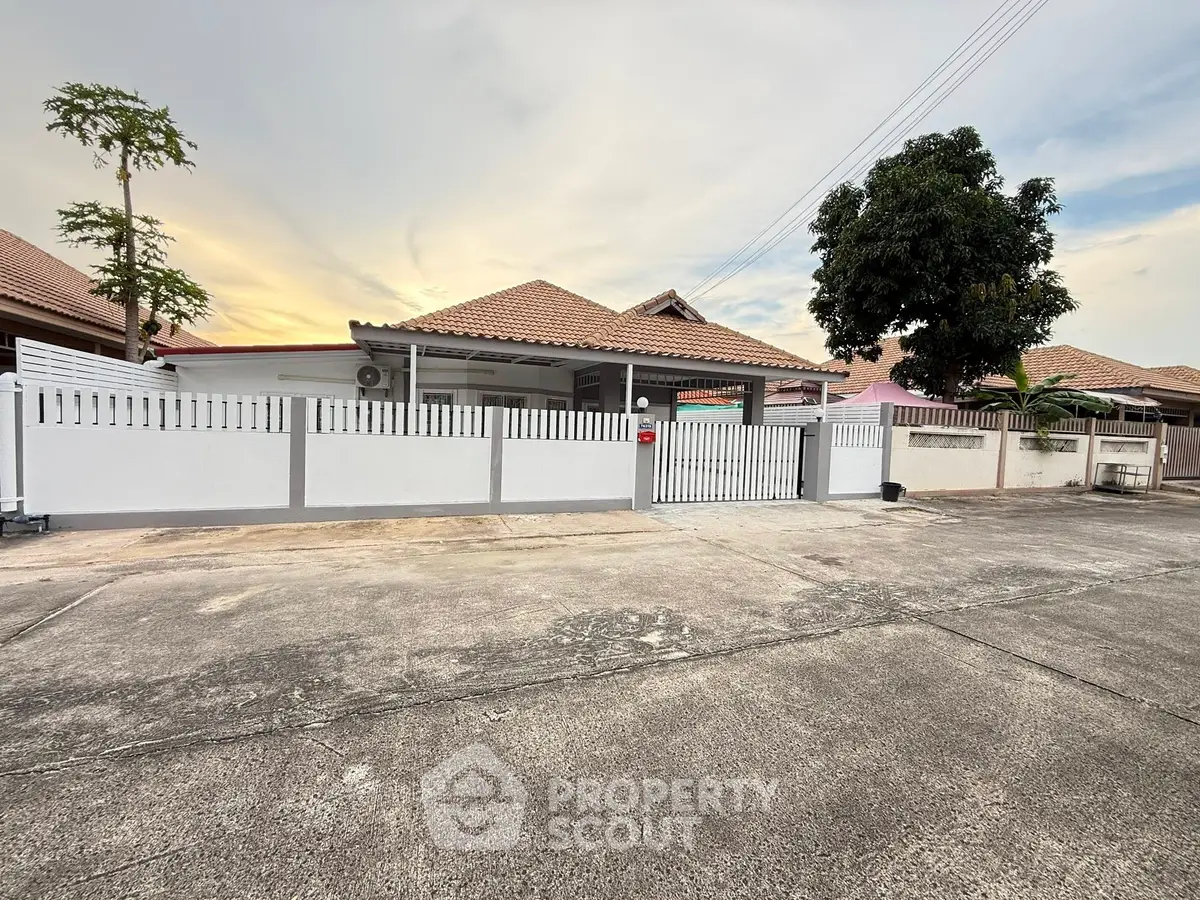 Charming suburban house with a spacious front yard and modern fence, perfect for family living.