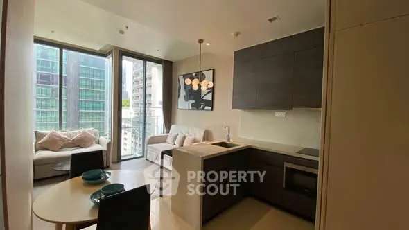 Modern open-layout living room with kitchen, featuring large windows and stylish decor in a high-rise apartment.