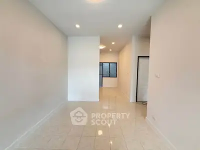 Spacious empty room with tiled flooring and recessed lighting, perfect for customization.