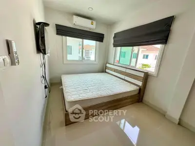 Bright bedroom with large windows and modern furnishings in a stylish home.