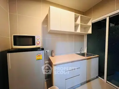 Modern kitchen with sleek cabinetry and compact appliances in a stylish apartment.