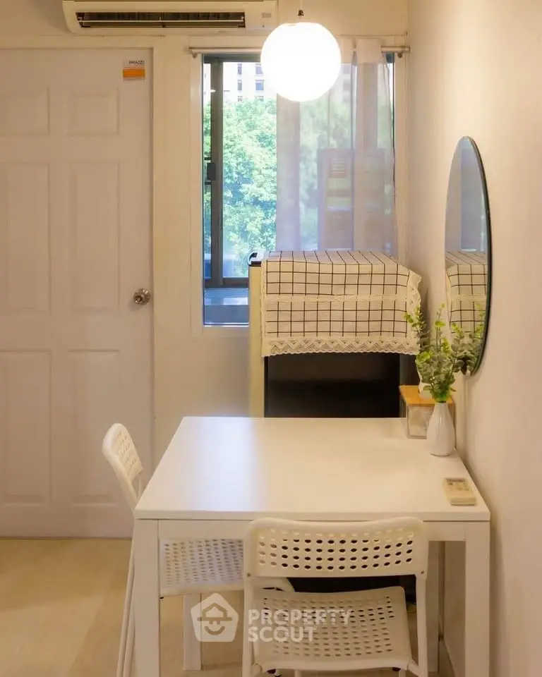 Cozy dining area with modern decor and natural light in a compact apartment.