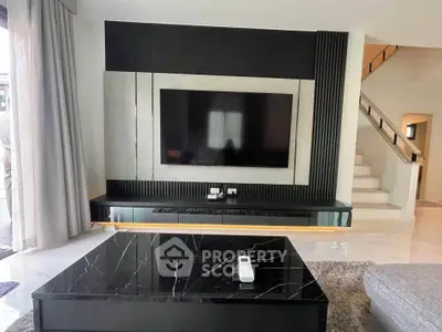 Luxurious modern living room with sleek black marble coffee table and large wall-mounted TV.