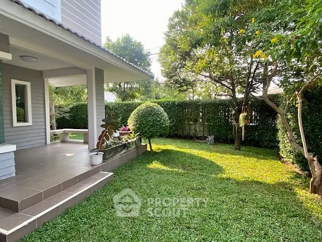 Charming suburban home with lush green garden and cozy patio area, perfect for relaxation and outdoor activities.