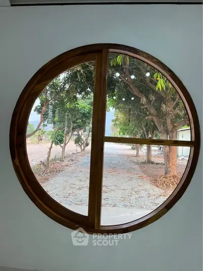 Unique circular window with scenic garden view in modern home
