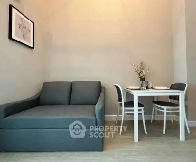 Cozy living room with modern sofa and dining set, perfect for small apartments.