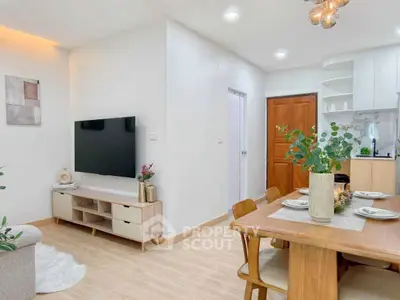 Modern living room with dining area, featuring sleek furniture and stylish decor in a bright, open space.