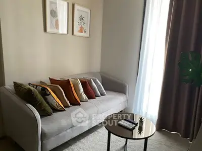 Cozy living room with modern sofa, colorful cushions, and stylish decor.