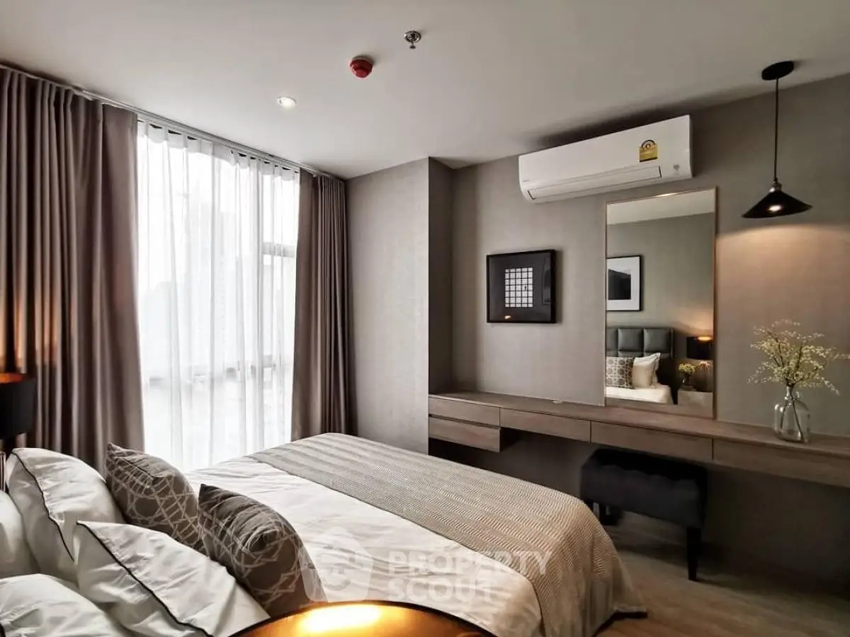 Modern bedroom with stylish decor and large window for natural light.