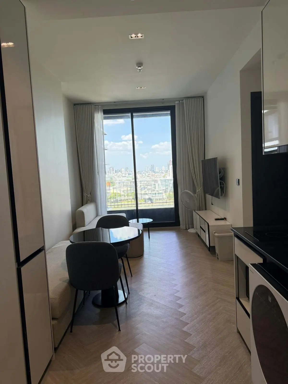 Modern living room with stunning city view, featuring sleek furniture and large windows for natural light.