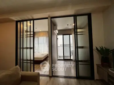 Modern apartment with sliding glass doors leading to a balcony and bedroom