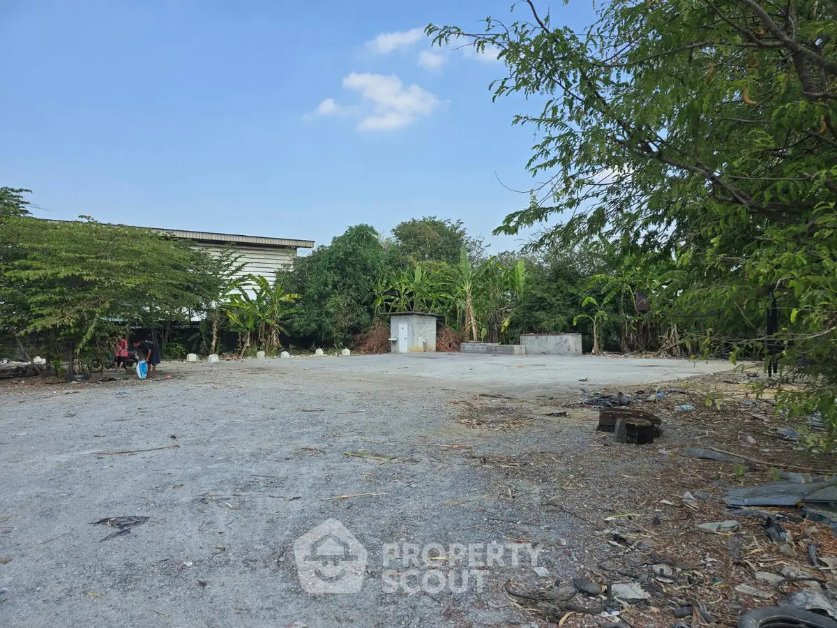 Spacious outdoor area with lush greenery and clear blue sky, ideal for development.