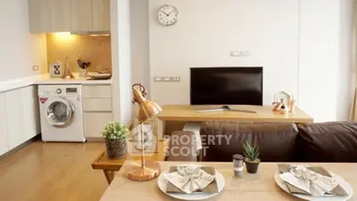 Modern living room with open kitchen and washing machine, stylish decor.