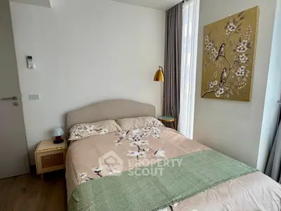 Cozy bedroom with elegant decor and natural light, featuring a stylish bed and artistic wall art.