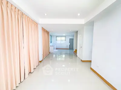 Spacious open-plan living area with glossy floors and large windows.