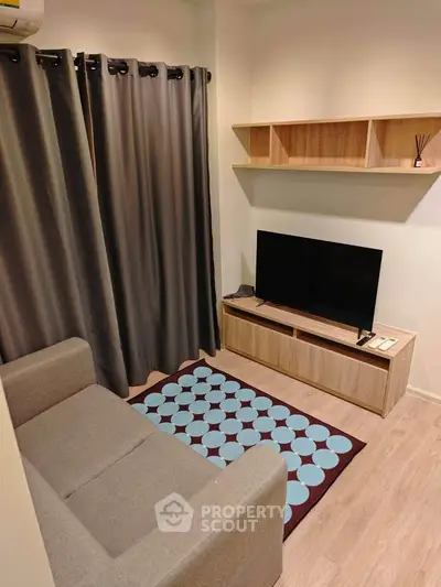 Cozy living room with modern decor, featuring a comfortable sofa, stylish TV stand, and elegant shelving.