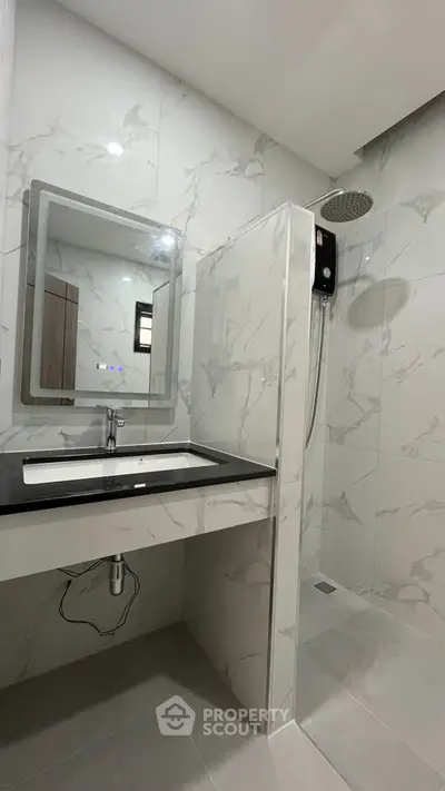 Modern bathroom with sleek shower and elegant vanity in a stylish home.